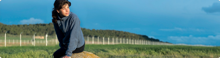 Family carrying canoe overhead on path in nature
